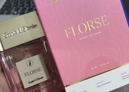 Aesthetic bottle of Florse Scents N Stories placed on a marble counter with delicate flowers around, lit by soft daylight.