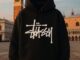 Close-up of Stüssy hoodie on a skateboarder in Lahore, blending Californian streetwear with Pakistani youth culture.