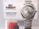 Tissot PRX watch with blue dial and stainless steel strap on a leather surface