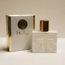 A bottle of YZY Perfumes placed on a wooden dresser with soft morning light